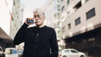 A man vapes from an e-cigarette on the street. | Eldar Nurkovic | Dreamstime.com