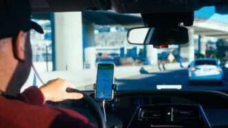 Someone drives car with a mounted smart phone showing a map | Photo by Paul Hanaoka on Unsplash