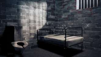A sparse, dark prison cell with only a bed and a toilet. Moonlight streams through the barred window. | Fernando Gregory | Dreamstime.com
