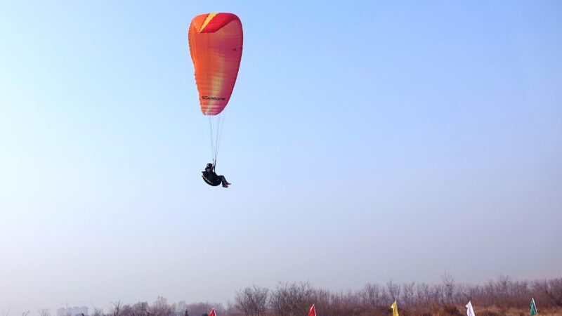 A paraglider in the sky. | Jinfeng Zhang | Dreamstime.com